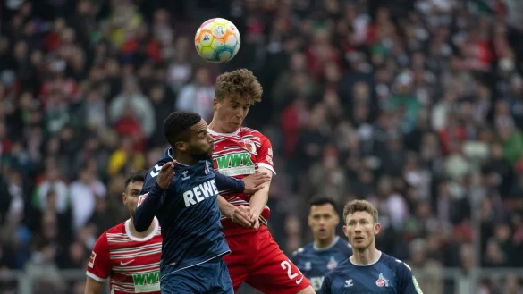 Augsburgs Arne Engels (r) und K&ouml;lns Linton Maina im Kopfballduell. - &copy; Stefan Puchner/dpa