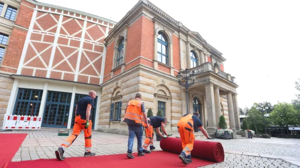 Der rote Teppich wird vor dem Bayreuther Festspielhaus ausgerollt. - &copy; Karl-Josef Hildenbrand/dpa