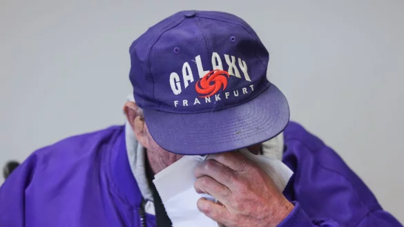 Ein Mann fordert wegen sexuellen Missbrauchs eine Million Euro Entschädigung von der katholischen Kirche - bei einer Pressekonferenz wischt er sich mit einem Tuch über das Gesicht. - © Oliver Berg/dpa