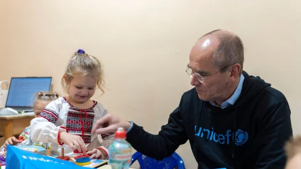 Der Gesch&auml;ftsf&uuml;hrer von Unicef Deutschland, Christian Schneider, mit einem ukrainischen Vorschulkind in einem Schutzraum unter der Erde: Das Kinderhilfswerk hilft Schulen und Kinderg&auml;rten in dem vom Krieg gepr&auml;gtem Land. - &copy; -/Unicef/dpa