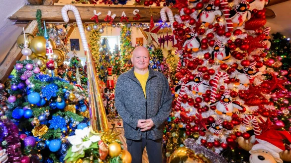 Thomas Jeromin steht inmitten von Weihnachtsbäumen in seinem Haus im Landkreis Schaumburg. - © Julian Stratenschulte/dpa