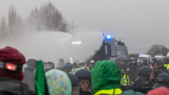 Die Polizei setzt Wasserwerfer gegen Demonstranten ein, die die B429 nahe der Lahnbrücke blockieren. - © Lando Hass/dpa