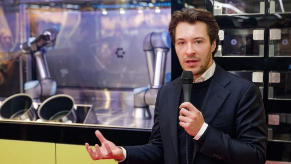 Circus-Gr&uuml;nder Bullwinkel spricht bei der Vorstellung des Kochroboters CA-1 in einem Rewe-Markt. (Archivbild) - &copy; Henning Kaiser/dpa