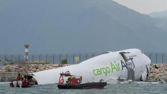 Die Frachtmaschine rutschte über die Landebahn hinaus ins Wasser. - © Chan Long Hei/AP/dpa
