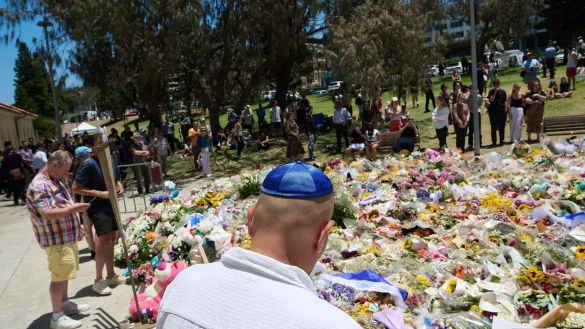 Menschen legen bei einer Gedenkfeier f&uuml;r die Opfer eines Terrorangriffs am Bondi Beach in Sydney Blumen nieder. (Foto aktuell) - &copy; Flavio Brancaleone/AAP/dpa