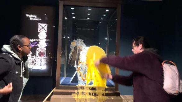 Aktivisten beschmieren die Vitrine, in der die Krone ist. - © Take Back Power/PA Media/dpa