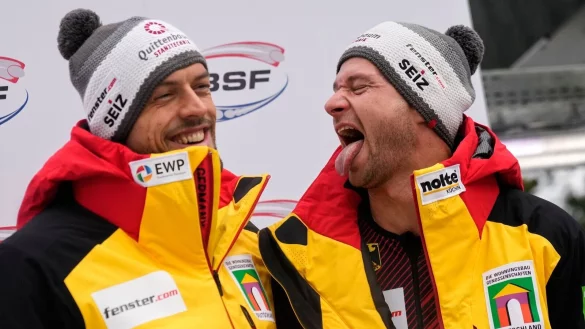 Johannes Lochner (r) und Georg Fleischhauer feiern den Sieg im Zweierbob. - © Matthias Schrader/AP/dpa