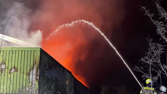 Es brennt lichterloh in der Lagerhalle. - © Justin Brosch/dpa