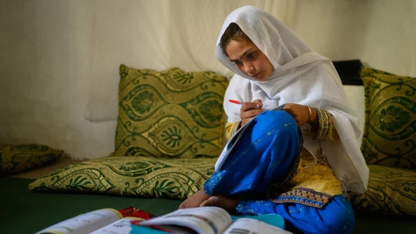 Die zehnj&auml;hrige Hajira aus der afghanischen Provinz Nangarhar sitzt in einem Haus in einem abgelegenen Dorf &ouml;stlich von Kabul &uuml;ber Schulb&uuml;chern und lernt. - &copy; Elise Blanchard/Unicef/dpa