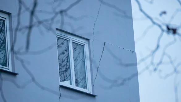 Rissen sind an der Fassade eines Mehrfamilienhauses zu sehen. Weil an mehreren Stellen der Boden abgesackt ist, ist das zweist&ouml;ckige Haus einsturzgef&auml;hrdet. (Archivbild) - &copy; Henning Kaiser/dpa
