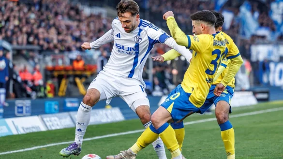 Die Braunschweiger Johan Gomez (verdeckt, Eintracht Braunschweig) und Robin Heu&szlig;er bedr&auml;ngen den Schalker Kenan Karaman (l). - &copy; Andreas Gora/dpa