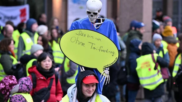 Besch&auml;ftigte der Uniklinik K&ouml;ln halten bei einem Warnstreik ein Skelett mit dem Schild &laquo;Das bin ich ohne Tarifvertrag&raquo; in die H&ouml;he. - &copy; Federico Gambarini/dpa