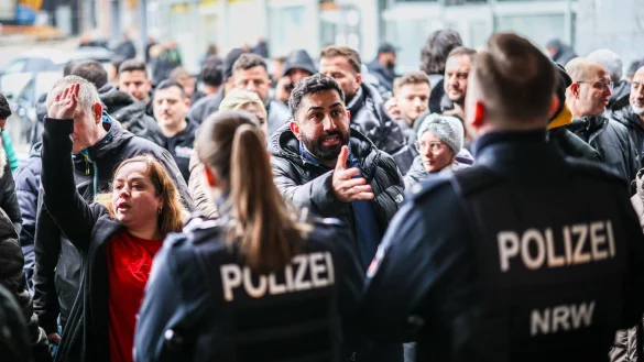 Aufgebrachte Kunden diskutieren vor der Sparkassenfiliale mit Polizeibeamten (Archivfoto) - &copy; Christoph Reichwein/dpa