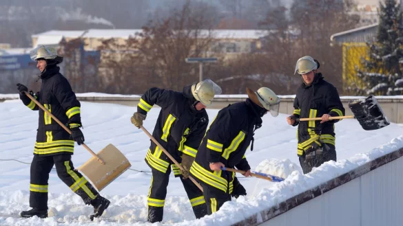 Ein Foto aus dem Jahr 2010 aus Gera in Th&uuml;ringen: Feuerwehrleute beseitigen Schnee vom Dach einer Turnhalle. So eine Unterst&uuml;tzung h&auml;tten die Menschen in Goch (NRW) nun wohl auch gern. (Archivbild) - &copy; picture alliance / ZB