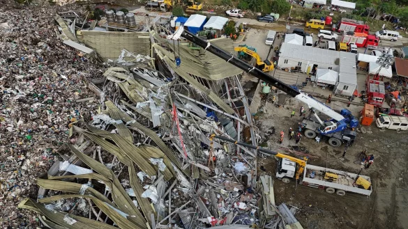 Die Einsatzkr&auml;fte suchen unter anderem mit einem Kran in den Abfall-Massen. - &copy; Jacqueline Hernandez/AP/dpa