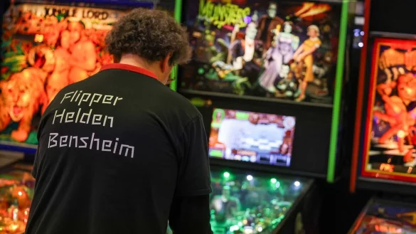 Teilnehmer stehen bei der Pinball Convention an Flipperger&auml;ten. - &copy; Christoph Reichwein/dpa