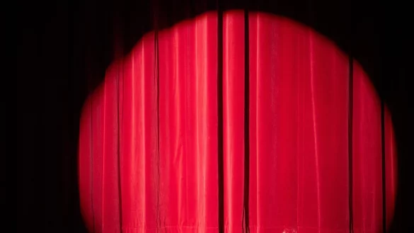 Ein Scheinwerfer erhellt den Vorhang auf einer B&uuml;hne. - &copy; Sebastian Kahnert/dpa/Symbolbild