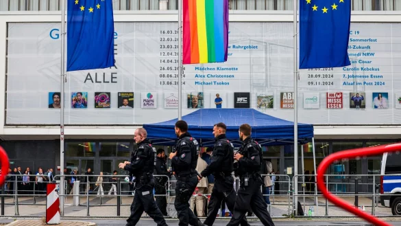Polizeibeamte laufen im Regen vor der Grugahalle entlang. Fortsetzung AfD-Bundesparteitag in Essen am Sonntag. - &copy; --/dpa