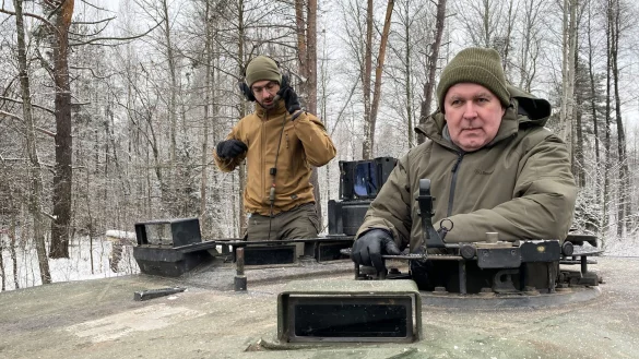 Arvydas Anusauskas (r), Verteidigungsminister von Litauen, und Sebastian Dietz, Leiter von Lithuania Defense Services (LDS), fahren auf einem Panzer. - &copy; Alexander Welscher/dpa/Archivbild