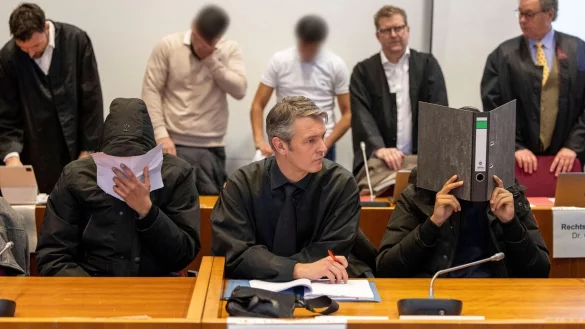 Vier der sieben Angeklagten und ihre Rechtsanw&auml;lte warten im Gerichtssaal auf den Prozessbeginn. - &copy; Thomas Banneyer/dpa