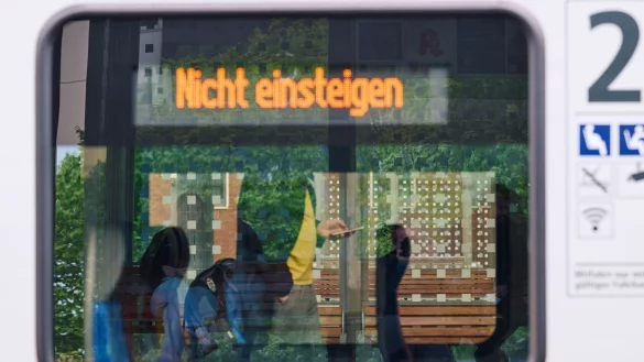 Ein Bahnreisender schaut am Hauptbahnhof auf sein Smartphone, w&auml;hrend in der Anzeige im Fenster eines Zuges &bdquo;Nicht einsteigen&ldquo; zu lesen ist. - &copy; Bernd Thissen/dpa