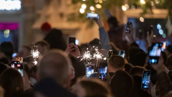 Menschen machen Fotos mit ihren Smartphones, w&auml;hrend sie den Jahreswechsel feiern. - &copy; Peter Kneffel/dpa