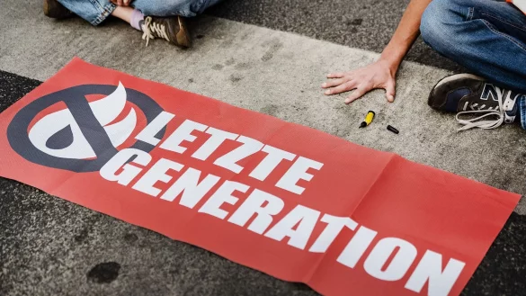 Ein Aktivist der Letzten Generation klebt seine Hand auf einer Straße fest. Solche Klebeaktionen hat die Gruppe inzwischen aufgegeben - und nun eine Kandidatur für das Europaparlament angekündigt (Archivbild). - © Swen Pförtner/dpa