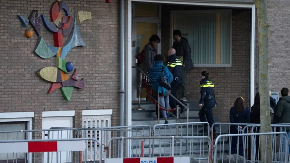 Zwei niederl&auml;ndische Polizeibeamte betreten das Hochsicherheitsgeb&auml;ude des Gerichts. - &copy; Peter Dejong/AP/dpa