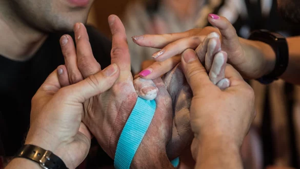Die beiden Schiedsrichter binden bei den Deutschen Meisterschaften im Armwrestling die H&auml;nde der Athleten mit einem Gurt zusammen, um ein erneutes Abrutschen zu verhindern. - &copy; Andreas Arnold/dpa