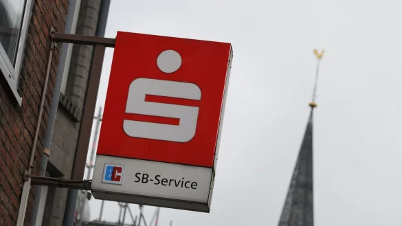 Das Logo einer Sparkasse hängt über dem Eingang einer Sparkassen-Filiale. - © Wolf von Dewitz/dpa-Zentralbild/dpa