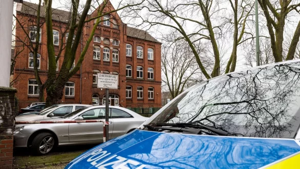 Ein Fahrzeug der Polizei steht vor der etwa 300 Meter vom Tatort entfernt gelegenen Schule. - &copy; Christoph Reichwein/dpa
