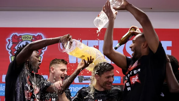 Leverkusens Trainer Xabi Alonso wird bei der Pressekonferenz nach dem Spiel von seinen Spielern mit Bier &uuml;bergossen. - &copy; Rolf Vennenbernd/dpa