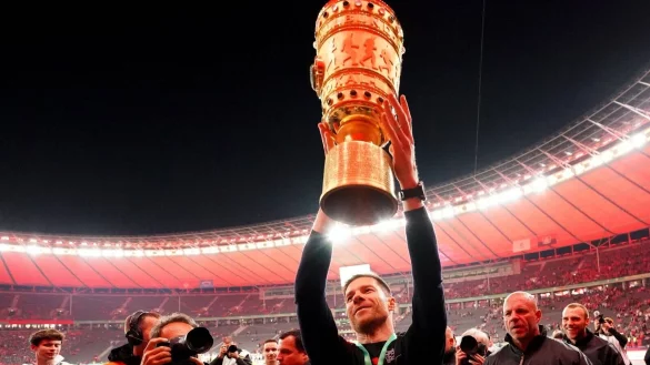 Leverkusens Trainer Xabi Alonso jubelt nach dem Sieg mit der Siegestroph&auml;e. - &copy; Uwe Anspach/dpa