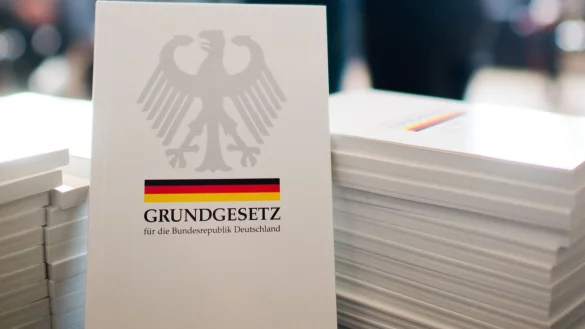 Das Grundgesetz der Bundesrepublik Deutschland liegt bei einer Einb&uuml;rgerungszeremonie aus. - &copy; Julian Stratenschulte/dpa/Symbolbild
