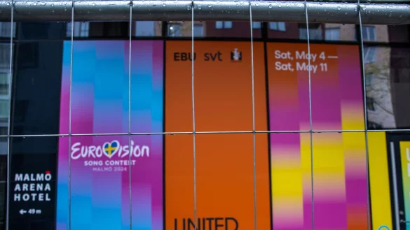 Werbetafeln f&uuml;r den EuroVision Song Contest h&auml;ngen hinter einem Metallzaun am Austragungsort Malm&ouml; Arena. - &copy; Jens B&uuml;ttner/dpa
