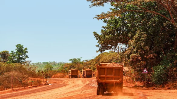 Lastwagen transportieren Bauxit entlang einer Bergbau-Transportstra&szlig;e. Laut einer Studie werden mehr als ein Drittel der Menschenaffenpopulation in Afrika durch Bergbau gef&auml;hrdet. - &copy; Claude Frenette/iDiv/dpa