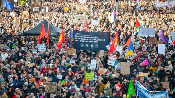 Mit Fahnen und Plakaten stehen die Demonstrierenden auf der Ludwig-Erhard-Stra&szlig;e in der Hamburger Innenstadt. - &copy; Jonas Walzberg/dpa