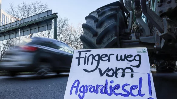 Ein Landwirt steht mit seinem Traktor und einem Schild mit der Aufschrift &bdquo;Finger weg vom Agrardiesel&ldquo;. - &copy; Oliver Berg/dpa