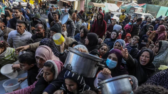 Vertriebene Palästinenser warten in Rafah, im Süden des Gazastreifens, auf Lebensmittel, die von palästinensischen Freiwilligen verteilt werden. - © Abed Rahim Khatib/dpa
