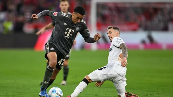 Bayern-Profi Jamal Musiala (links) dribbelt an Leverkusens Alejandro Grimaldo vorbei. - © Sven Hoppe/dpa