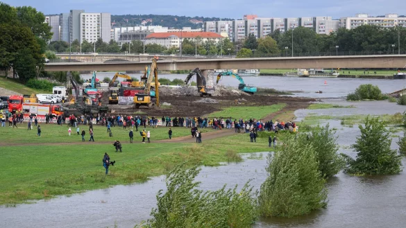 Zahlreiche Schaulustige verfolgen am Elbufer den Abriss der eingestürzten Carolabrücke. - © Robert Michael/dpa
