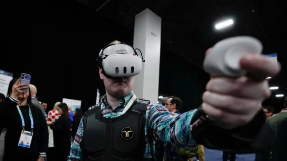 Ein Besucher probiert auf der CES die haptische Weste von bHaptics. Die Weste soll in Verbindung mit Augmented-Reality-Systemen verwendet werden, um haptisches Feedback in Videospielen zu geben. - &copy; Ryan Sun/AP/dpa