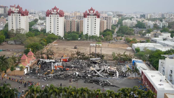 Arbeiter beseitigen nach einem Brand in einer Spielhalle die Tr&uuml;mmer. Dabei sind mehrere Leichen geborgen worden. - &copy; Ajit Solanki/AP/dpa
