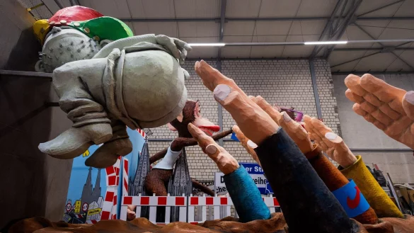 Ein Motivwagen, der einen Hintern und zum Hitlergru&szlig; ausgestreckte Arme zeigt, steht beim Richtfest f&uuml;r den K&ouml;lner Rosenmontagszug im Karnevalsmuseum. - &copy; Rolf Vennenbernd/dpa