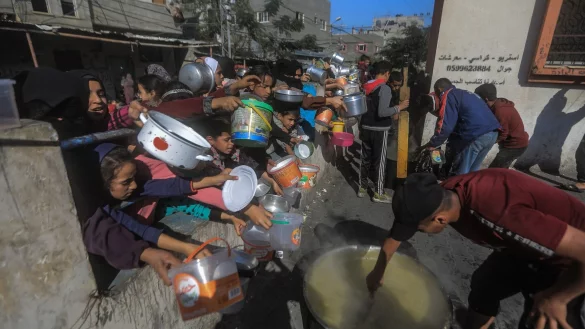 Rafah im Dezember: Pal&auml;stinenser versammeln sich mit T&ouml;pfen, um an einer von einer Wohlt&auml;tigkeitsorganisation eingerichteten Spendenstelle Essen zu erhalten. Die humanit&auml;re Lage im Gazastreifen ist nach f&uuml;nf Monaten Krieg katastrophal. - &copy; Mohammed Talatene/dpa