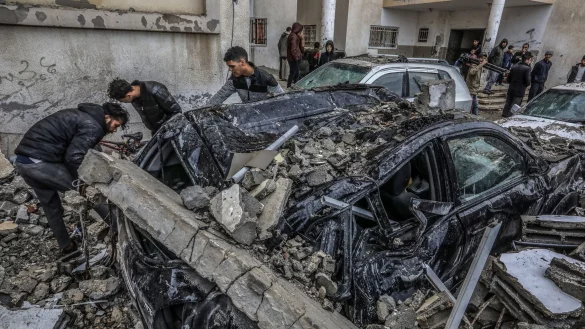 Pal&auml;stinenser inspizieren zerst&ouml;rte Fahrzeuge nach einem israelischen Luftangriff. - &copy; Abed Rahim Khatib/dpa