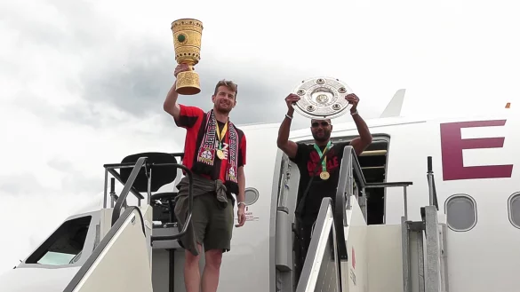 Leverkusens Torh&uuml;ter Lukas Hradecky (l) und Leverkusens Jonathan Tah steigen mit dem Pokal und der Meisterschale auf dem Flughafen K&ouml;ln/Bonn aus dem Flugzeug. - &copy; Sascha Thelen/dpa