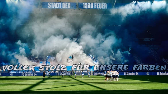 Schalkes Fans feiern ihre Mannschaft mit einer Choreografie vor dem Spiel - auf dem Banner steht "Voller Stolz für unsere Farben". - © Bernd Thissen/dpa