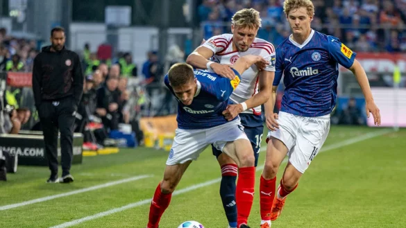 Kiels Marko Ivezic (l-r), D&uuml;sseldorfs Jona Miemiec und Kiels Tom Rothe k&auml;mpfen um den Ball. - &copy; Axel Heimken/dpa