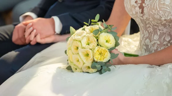 Ein Brautpaar h&auml;lt sich w&auml;hrend ihrer Trauung die H&auml;nde. - &copy; Silas Stein/dpa